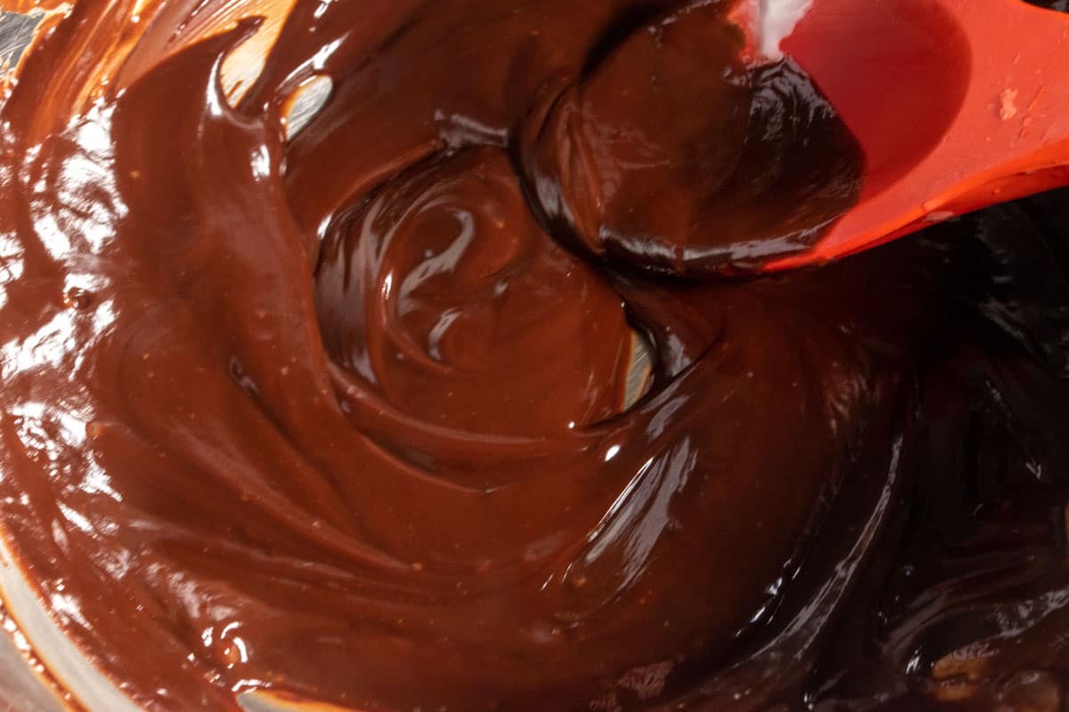 Melted chocolate being stirred inside a large bowl. 