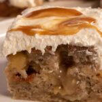 A gooey piece of my vegan banana pudding poke cake which is filled generously with pudding.