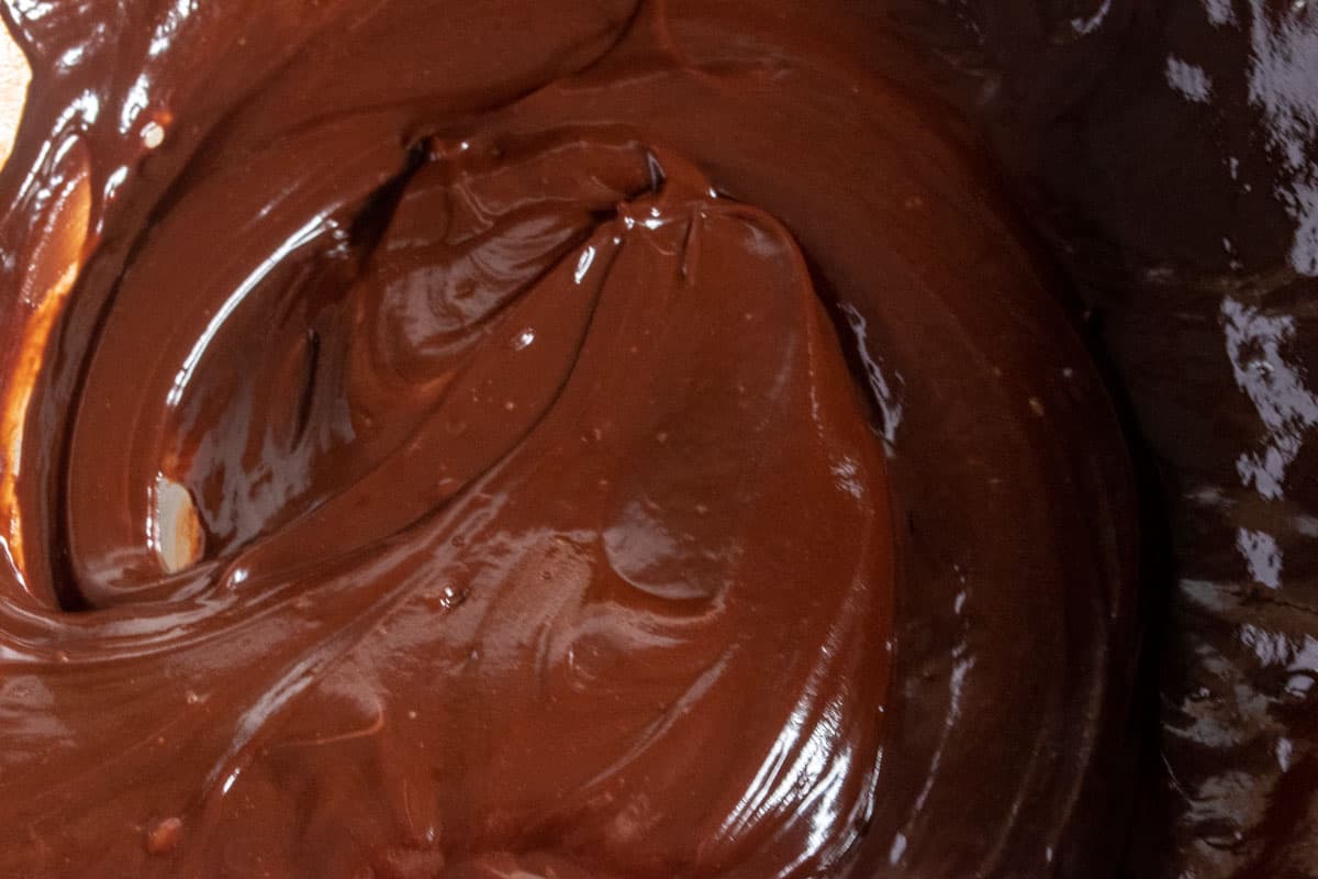 Chocolate being melted inside a large, metal bowl. 