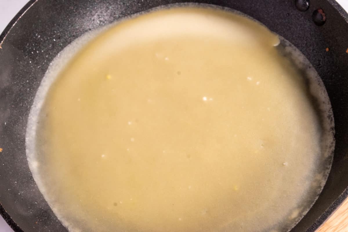 A super thin crepe frying inside the hot pan. 