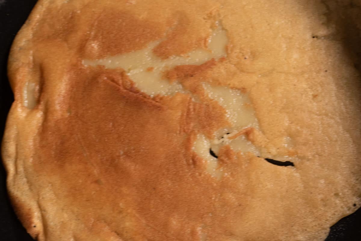 A golden brown, cooked crepe inside the pan. 