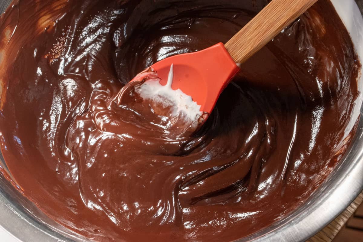 Melted chocolate being stirred inside a large bowl. 