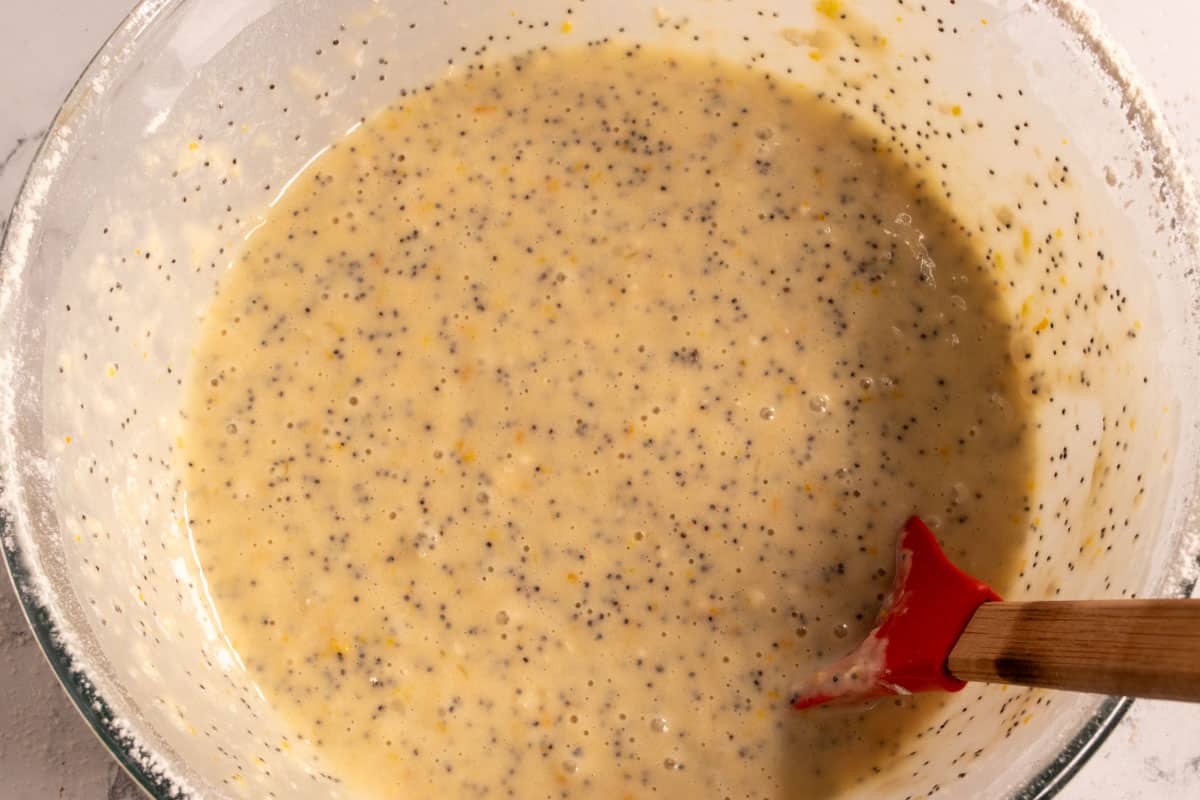 A poppy seed filled cake batter inside the pyrex bowl. 
