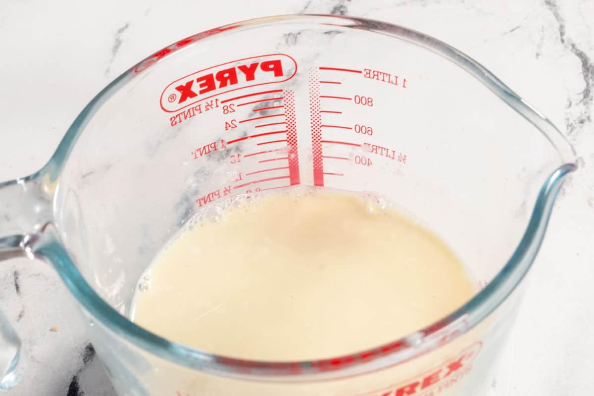 The vegan buttermilk curdling inside a pyrex jug.