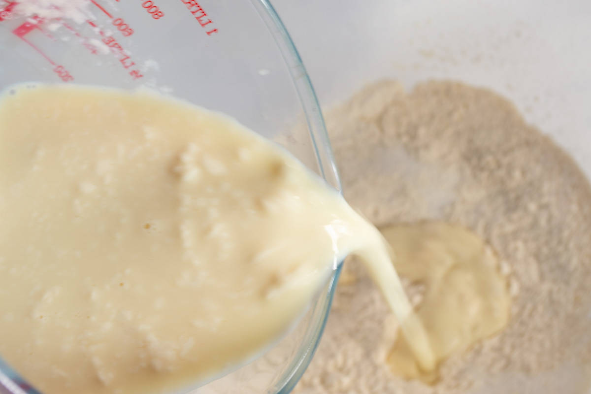 The curdled soy milk being poured into the dry ingredients.