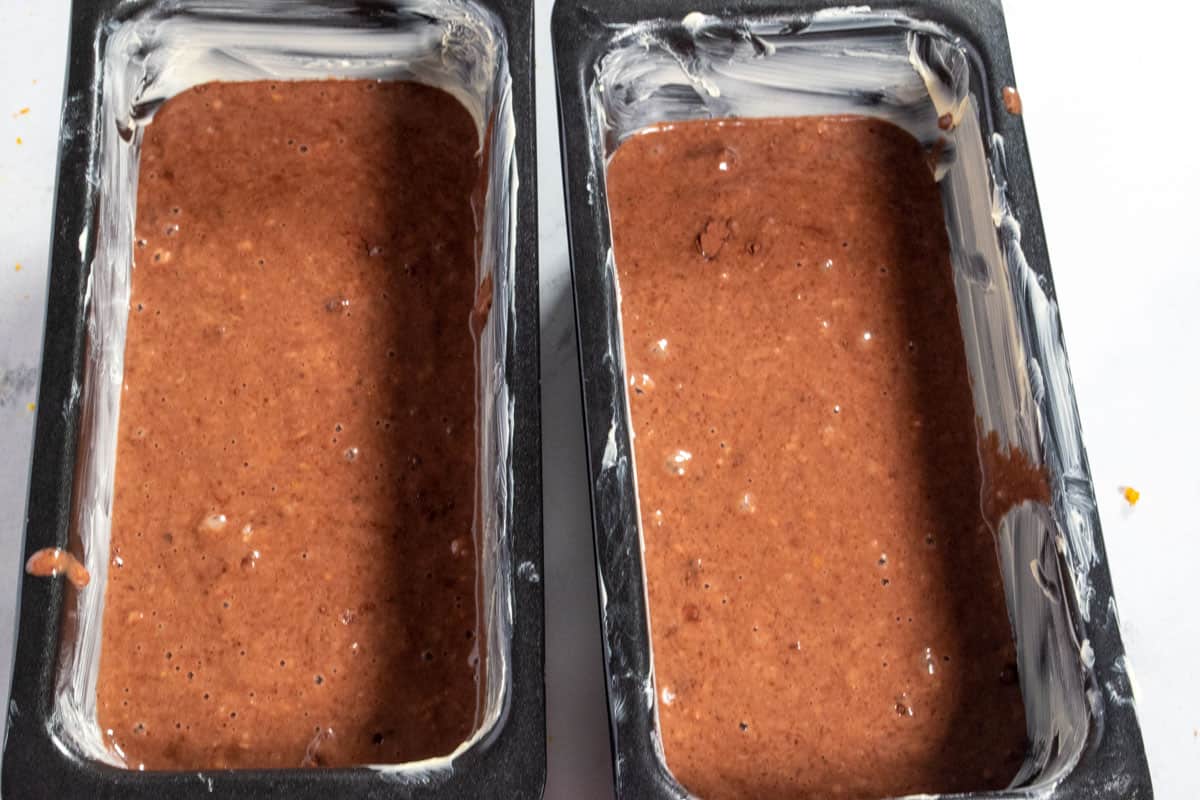 The cake batter has been poured into the two cake tins. 