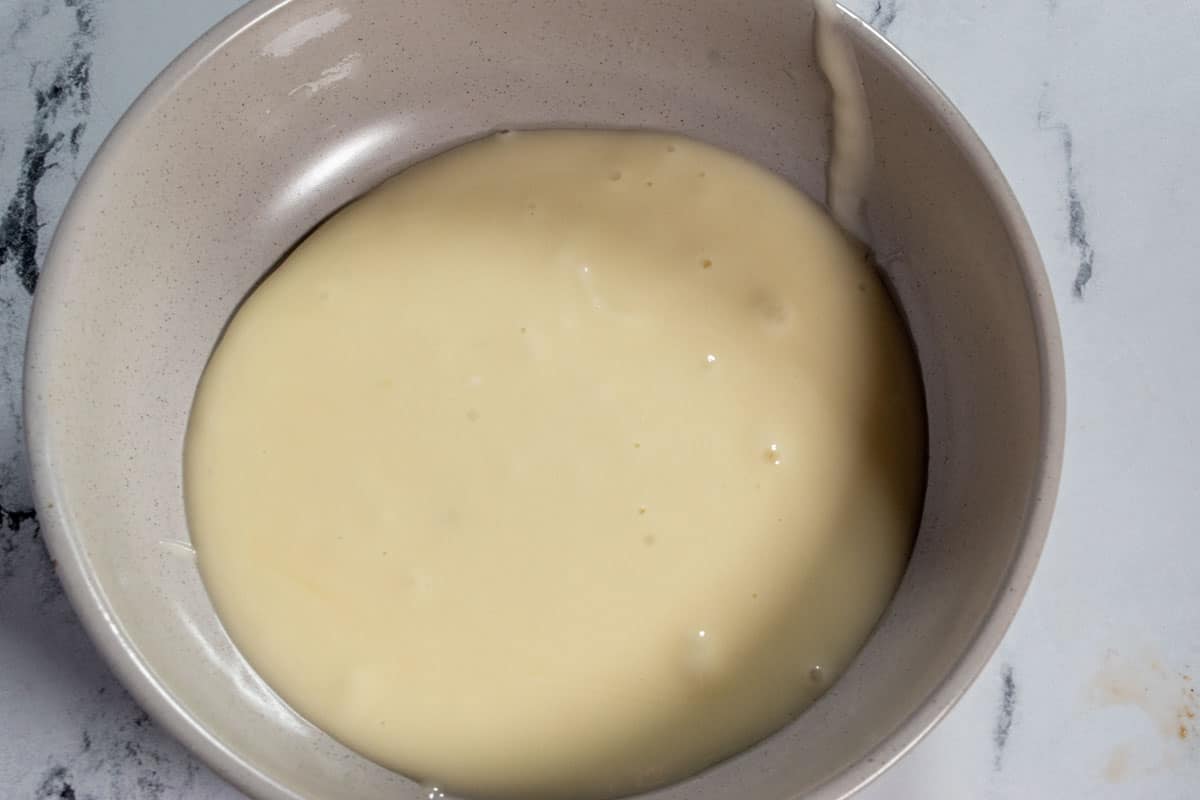 The orange glaze for the cake in a small bowl.