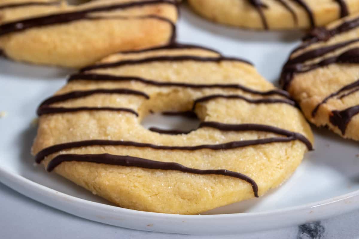 A plate full of baked vegan fudge stripe cookies. The chocolate has set on top.