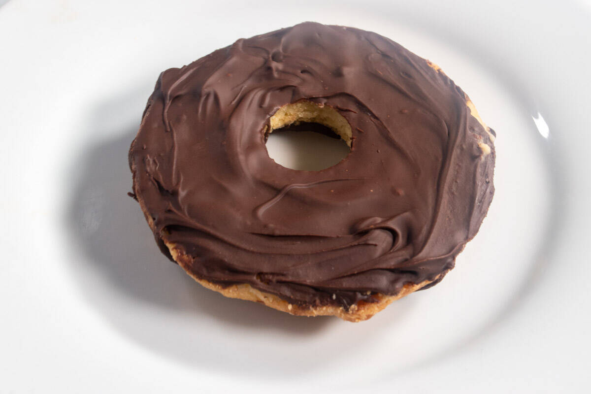 The bottom of a cookie is also decorated with firm chocolate layer on a white plate.