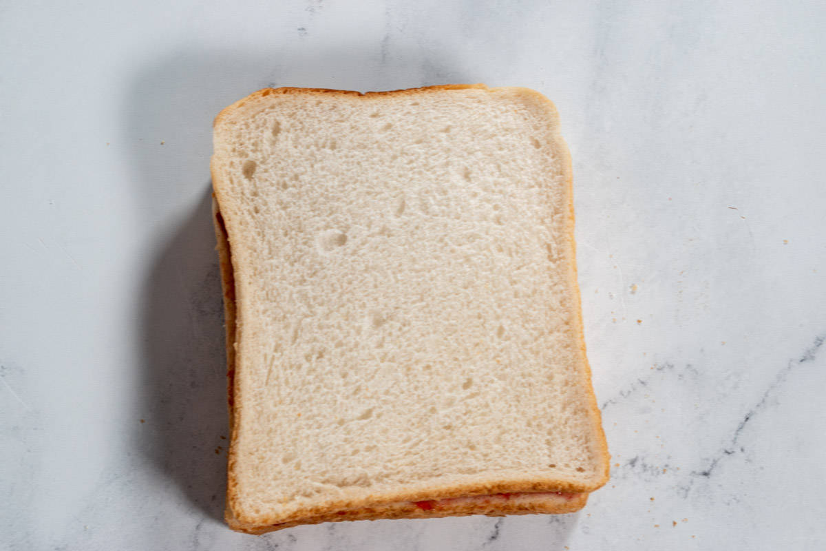 A sandwich has been created. It sits over a white background.