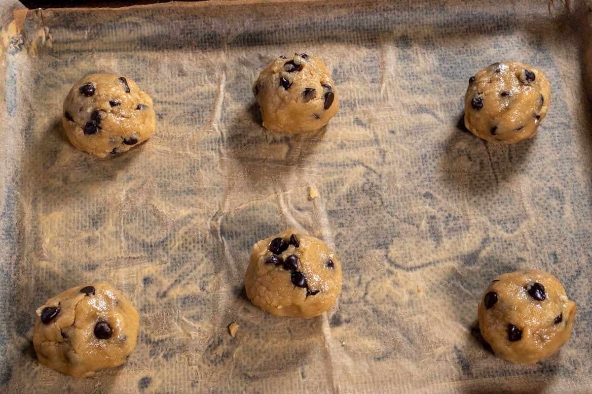 The chilled cookie dough on a baking tray, rolled into balls. 