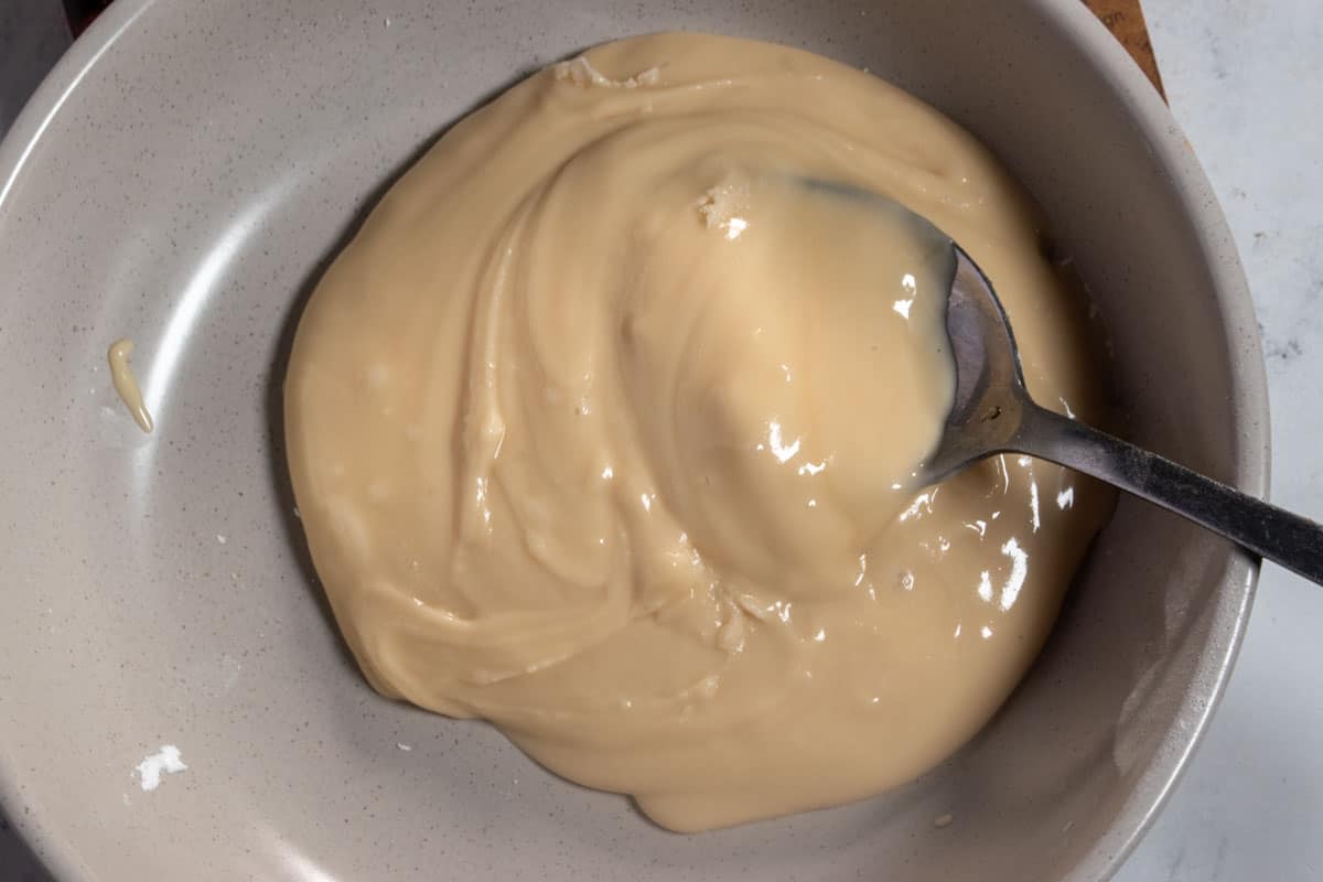 The maple syrup glaze topping mixed together inside a small, grey bowl. 
