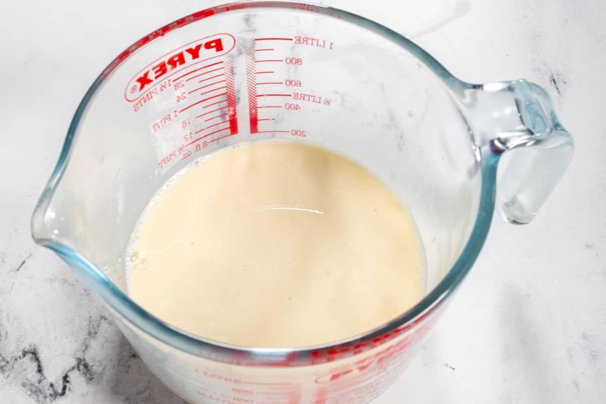 The vegan buttermilk curdling in a pyrex measuring jug.