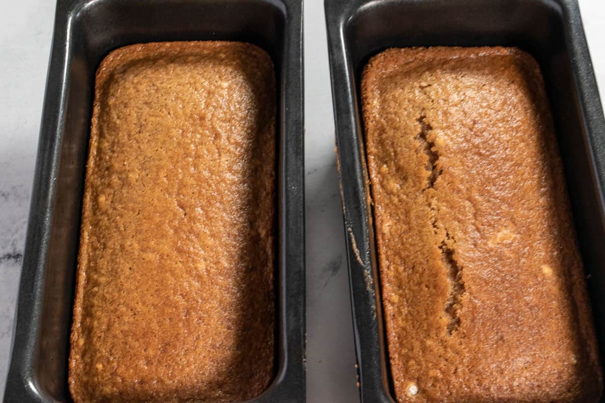 The two golden brown cakes are cooling down inside the tins after being baked. 