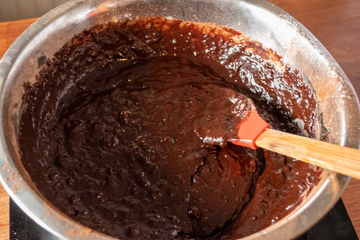 The brownie batter folded together inside the mixing bowl. 